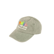 Green cap with colorful logo and text on a light beige background