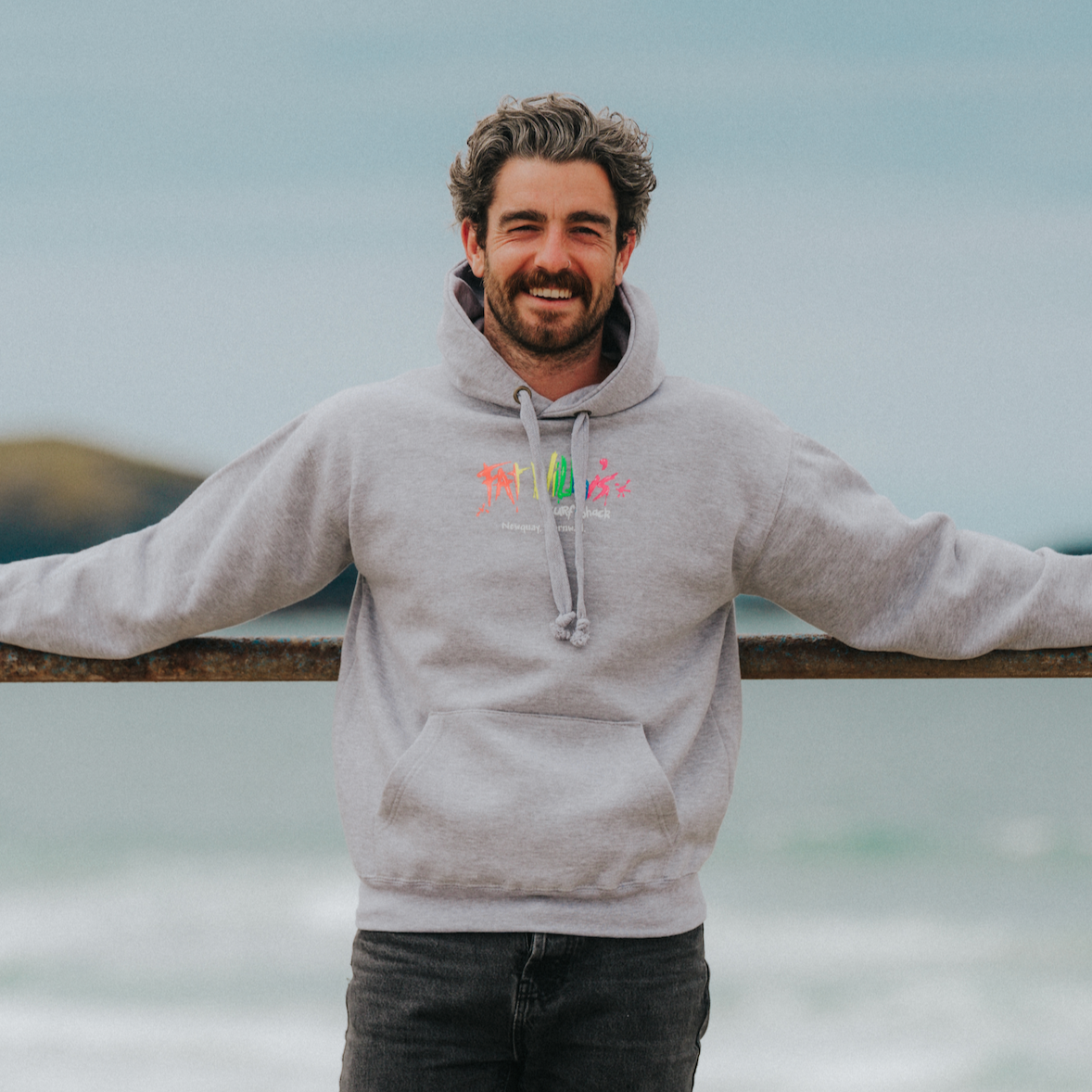 Model wearing sport grey Fat Willy’s hoodie outdoors with retro logo visible